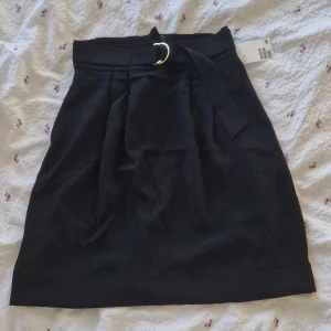 Svart kjol - Kjol från H&M. Aldrig använd, lappen sitter kvar. Skärp i midjan