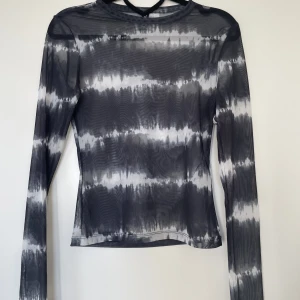 Figurnära mönstrad meshtopp - En topp i mesh använd fåtal gånger som är sydd figurnära, dvs ej rak utan går inåt i midjan och följer kroppsfiguren. 