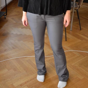 Lågmidjade kostymbyxor - Gråa Lågmidjade kostymbyxor köpta på plick. Lite slitna längst ner bak, skriv för bild. Midjemått: ca 40 Innerben: ca 83