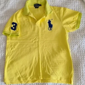 Ralph Lauren pikétröja stl L custom fit  - Knappt använd, nyskick polo Ralph Lauren piké stl Large, gul färg med marinblåa big pony kommer ifrån ett rökfritt djurfritt hem samt är fläckfritt såklart. Nypris på outlet 899:-. Mitt pris 180:- inklusive frakt.