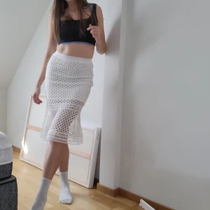 Vut kjol i spets - Kritvit kjol med håligt / spets-aktigt tyg med dragkedja där bak och resår. Superhäftig volang där nere med annorlunda spetsdetalj vid knäna och längst ner. Nyskick. Svarar på alla frågor 🥰