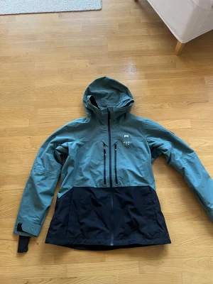 Skidjacka  - Skaljacka för skidåkning. Använd en vecka i fjällen förra året. Nypris 2000kr  Snölås finns Innerficka finns  Finns fack till liftkortet  Luftinsläpp i armarna finns