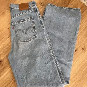 Ett par fina ljusblå jeans från Levis jeans i en straight loose modell. Knappt använda. Storlek 26. Hör av er om ni har några frågor!