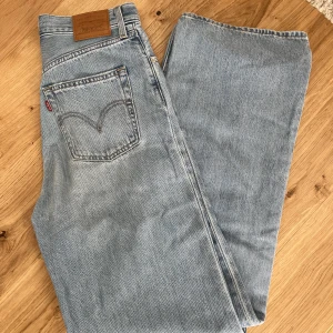 Ljusblå Levis jeans  - Ett par fina ljusblå jeans från Levis jeans i en straight loose modell. Knappt använda. Storlek 26. Hör av er om ni har några frågor!