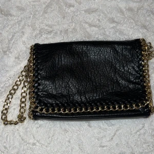 Tiamo väska  - Tiamo väska, modell ”pricilla” stl.M. Svart skinn med guldig kedja. Använd skick men inga avvikelser/skador