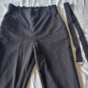 Paperbag byxor stl 40 - Svarta paperbag byxor med tillhörande bälte (går dock lika bra att använda utan/med annat bälte) från H&M. Storlek 40. Fint skick, endast använda ett par gånger :)
