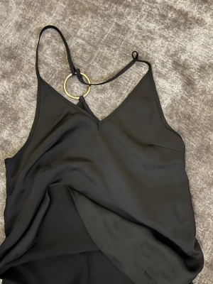 Linne - Ett super fint svart silkes linne med en guld ring i S