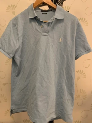 Sällsynt Ralph Lauren Piké - Sällsynt ljusblå ralph lauren piké. Felfri utan tecken av användning. Kan mötas upp men även frakta. Storlek L, men sitter som M.
