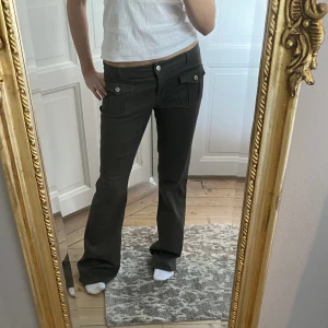Gröna lågmidjade jeans - Sjukt snygga och trendiga lågmidjade bootcutjeans i en mörk olivgrön färg❤️supercoola fickor. Perfekt skick! Storleken passar M/L. Skriv vid funderingar och kolla in mina andra annonser🤩