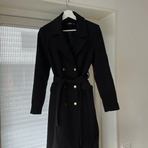 Svart Kappa  - Svart kappa med guld detaljer samt skärp i stl 36. Inköpt på Gina tricot.