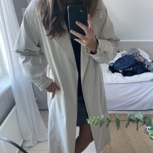 Lång beige trenchcoat  - Säljer den populära trenchcoaten från Nelly. Den ser ut ny och är helt slutsålda. Nypris 899 kr🥰