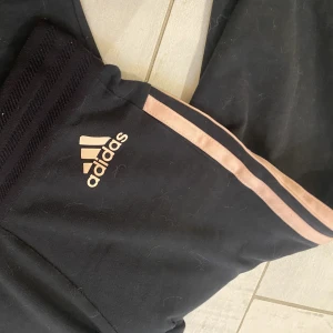 Adidas tights - Sköna Adidas tights med aprikosfärgade streck, fint skick förutom ett litet hål på vänster ben (man kan sy ihop det men det märks inte så mycket). 