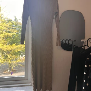 Beige ribbad klänning - En fin beige klänning som är ribbad med en lite högre krage. (Inte turtle neck). Använd vid ett fåtal tillfällen