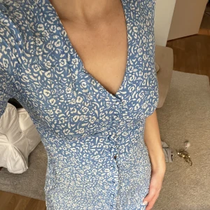 Sommar klänning 🌸 - Medellång blå vit blommig sommarklänning med knappar hela vägen ner. 