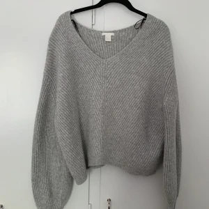 Stickad tröja - V-ringad stickad tröja med långa ärmar. 
