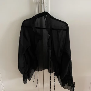 Blus  - Blus som är rätt genomskinlig från H&M, man knyter typ på fyra ställen, lik djerf aveny🥰
