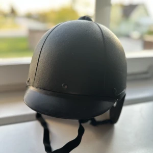 Ridhjälm  - Ridhjälm  Storleken gissar jag lite på för att den är förstor för mig som har storlek 54-56 i ridhjälm. Den har lite repor på sidan av hjälmen, Den är en lite äldre model och därför lite billigare pris. Skickat mot frakt och kan mötas upp i Karlskoga  