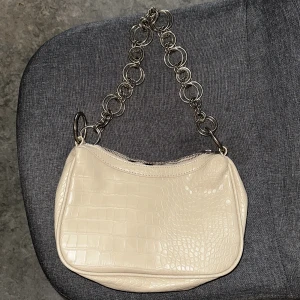 NLY Accessories beige handväska - Beige handväska med kedjehandtag i form av ringar. Använd bara ett fåtal gånger men är i väldigt fint skick. 
