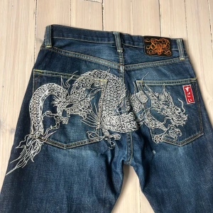 Sugoi dragon jeans - Tja! Säljer dessa jätte snygga jeans som har sytt print på fickorna, dessa byxor är väldigt ovanliga, och i bra skick. Hoppas du vill köpa