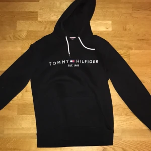 Svart Tommy Hilfiger hoodie - Använd ett fåtal gånger, jätte bra skick. Storlek M. Nypris runt 1000kr säljes för 450kr