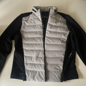 Sailracing jacka - Gråsvart sailracing jacka. Lite tunnare jacka som passar bra på vår/höst eller till träning! Använd 1 gång.