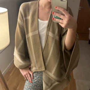 Beige poncho - Beige poncho med mönster, aldrig använd 