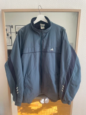 Retro adidasjacka - Retro adidas jacka, inköpt på beyond retro. Har använt den och tröttnat helt enkelt, älskade den innan! Inte särskilt varm men skyddar mot vind. Vet inte vilken storlek, skulle kunna passa allt från S-Xl. Jag har M och den sitter oversized på mig!