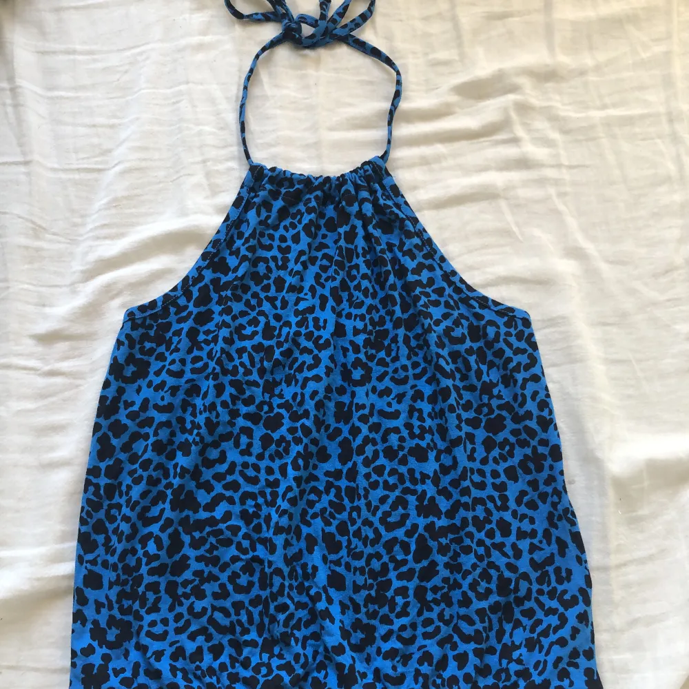 Säljer denna blåa halternecktoppen med svart leopard mönster från bikbok💘 storlek xs och knappt använd😁OBS: det vita fläckarna som syns på bild ett är på spegeln och inte på plagget!!💕. Toppar.