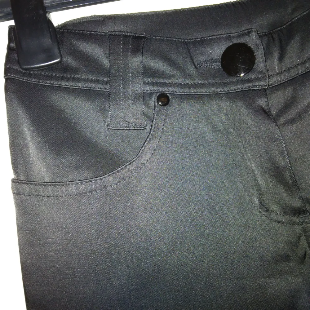 Svarta smala satinbyxor/ byxor I satin, strlk: 32. Felfria. Stängs med dragkedja och knapp samt har fickor. Första bilden är ett exempel på liknande modell och passform.. Jeans & Byxor.