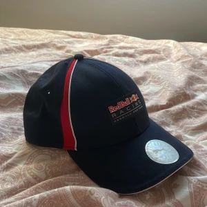 Puma keps  - Säljer denna Puma redbull racing keps då den aldrig kommer till användning, använd ett fåtal gånger men är som ny. Inga defekter. Spänne baktill så att man kan ändra storleken, 7 olika nivåer på spännet. Texten är 3D.