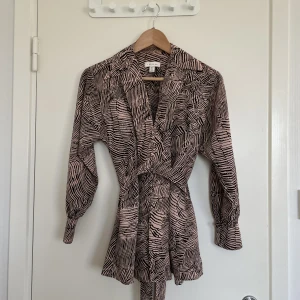 Blus topshop storlek 34/XS - Smickrande blus från Topshop med ballongärmar och knytband i midjan. Storlek 34. Härligt zebramönster i beige-rosa färg. Endast använd ett fåtal gånger