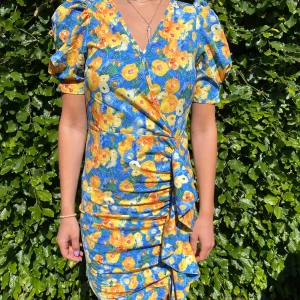 Blommig sommarklänning  - En blommig sommarklänning men lite piffigare ärmar