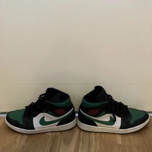 Jordan 1 mid pine green - Ett par använda Jordan one mid pine green i storlek 44, har ingen låda och är använda, har lite heeldrag och lite av färgen har flagnat långt fram på ena skon