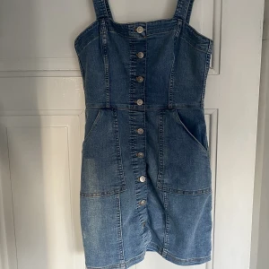 Hängselklänning jeans - Hängselklänning i jeans, sitter tajt på kroppen. Justerbara band och fickor! Från H&M. Något ljusare i verkligheten. 
