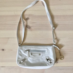 Vit axelväska - Rensar garderoben! Unik vit axelremsväska med detaljer. Går att ställa in bandet till önskad längd 💕