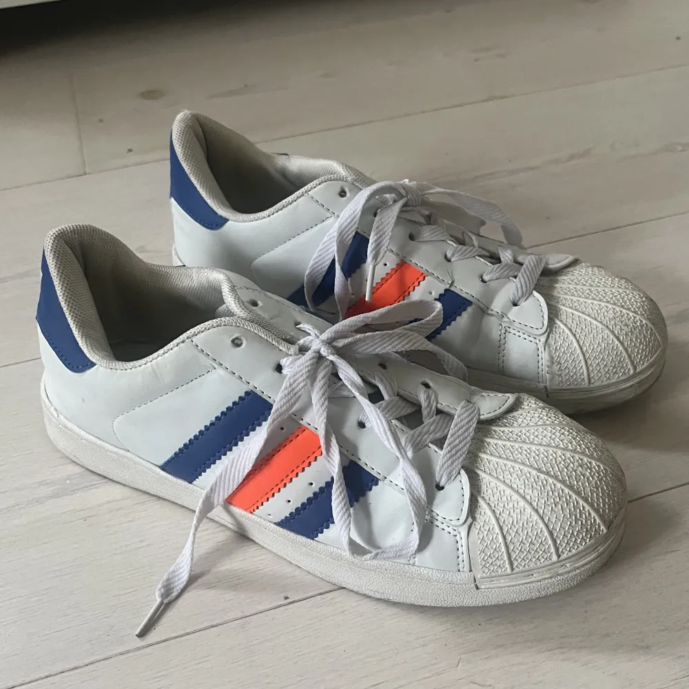 Adidas skor med blå och orangea ränder. Använda ett fåtal gånger💙🧡. Skor.