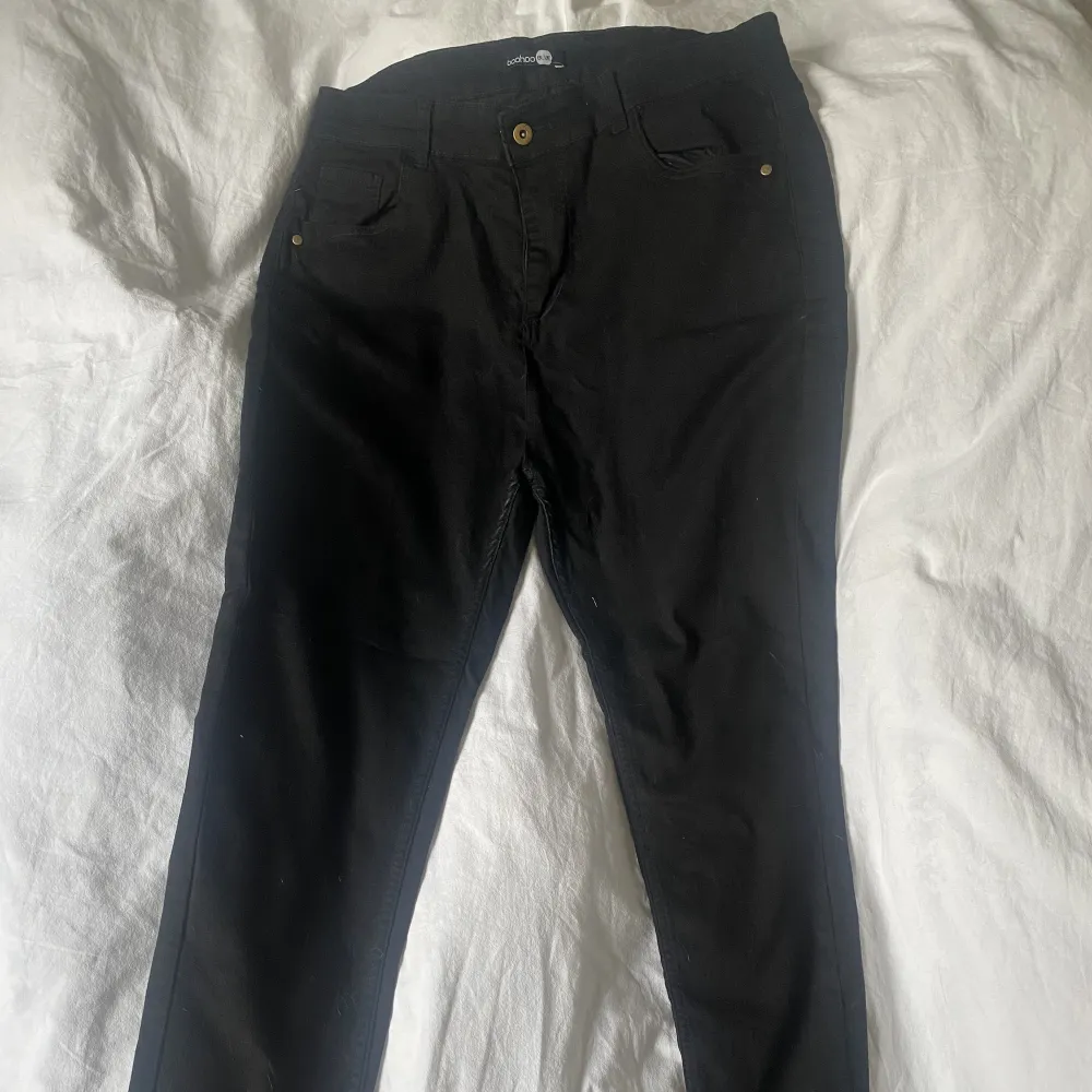 Ett par svarta stuprörsjeans i storlek 46 ifrån boohoo med stretchiga material  Midja 46 cm Lår 22 cm Längd 107 cm. Jeans & Byxor.