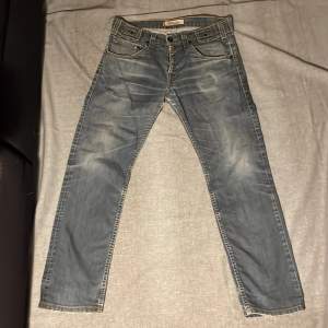 Ett par blåa Levis504 jeans. Byxorna är i storlek W32 L34 och är i straight fit. Det finns fläckar på baksidan av det vänstra benet och därav priset. Hör av dig för fler bilder eller frågor. Mvh Scandinav garderoben.