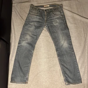 Blåa Levis504 jeans - Ett par blåa Levis504 jeans. Byxorna är i storlek W32 L34 och är i straight fit. Det finns fläckar på baksidan av det vänstra benet och därav priset. Hör av dig för fler bilder eller frågor. Mvh Scandinav garderoben.