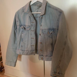 JEANSJACKA - Sliten jeansjacka i en kortare modell från Gina Tricot!