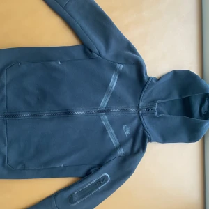 Nike tech - Svart Nike tech i storlek 147-158. Använt den Max 5 gånger är inte min stil längre. Köpt den från JD. Ordinarie pris var runt 900kr, säljs för 650kr.