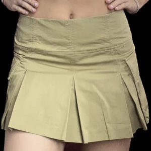 Militärgrön cargokjol - Säljer denna coola cargokjolen. Den är köpt på Zara i usa och finns ej att köpa i Sverige. Den är använd en gång. Även om den är kort så har den små skotta inuti gjorda av samma tyg. Fickorna vid sidan är riktiga. 