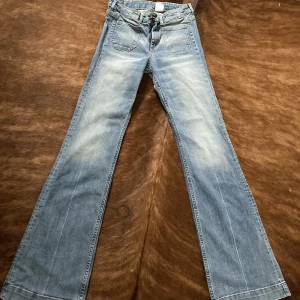 Flared jeans - ⚡️flared blåjeans. Strl.27. Lite stretch. Total längd- 110cm Innerben-83,5cm Midja rakt över-33,5cm Stuss-40cm Gren-25cm Benslut-26cm  Vid stort intresse aktiverar jag budgivning.