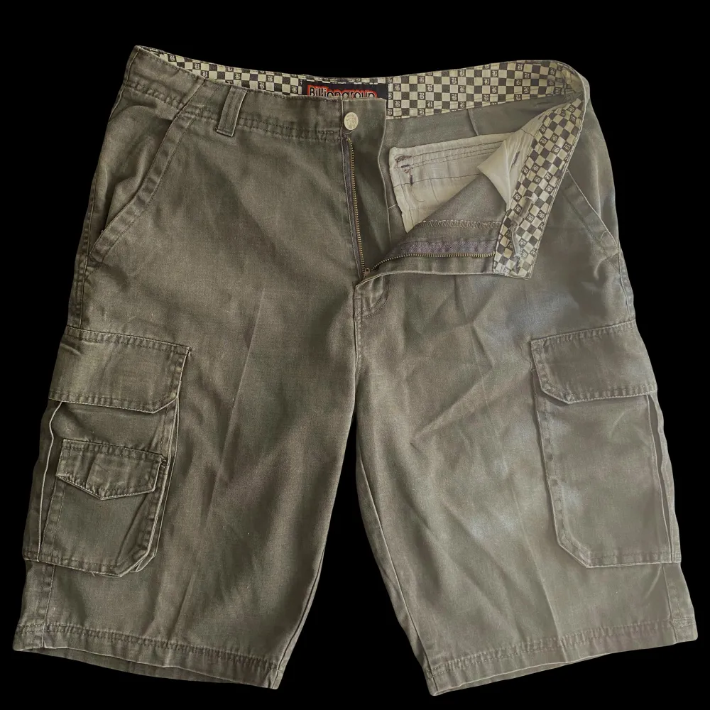 Vintage militärgröna cargo shorts, som är i bra skick. Skriv gärna innan ni köper. Midja 49 cm (går dock att justera med snörerna) Från gylfen till längst ner 39 cm.. Shorts.