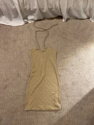 Beige klänning  - Beige tajt klänning som har öppen rygg. Väldigt fin passform!