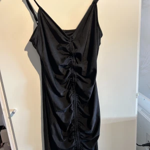 Party klänning  - En kort klänning som går nedanför rumpan. Stretchigt material med dragkedja bak. Justerbara axelband. Storlek 38