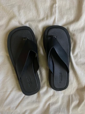 Tofflor - Svarta tofflor ifrån ASOS i läderimitation, helt oanvända! 