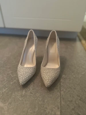 Vita skor med pärlor - Passar perfekt till brud  Har två olika storlekar en 37:a och den andra 38:a