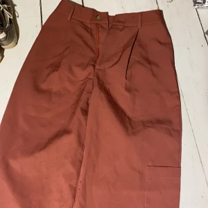 Kostymbyxor  - Vida kostymbyxor med en ficka på vänster ben 