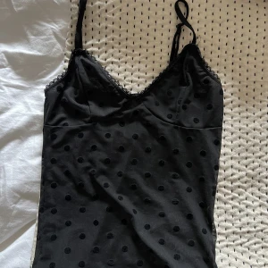 Svart linne - Svart linne med svarta prickar ifrån Nelly.com! Materialet täcker bysten men är lite lätt genomskinligt på magen och ryggen. Använd 1 gång så gott som ny.  